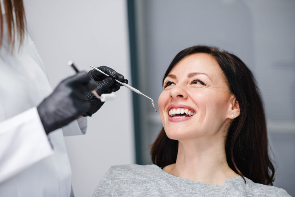 smiling young woman in dental chair about to undergo a procedure after learning the importance of individualized dental treatments