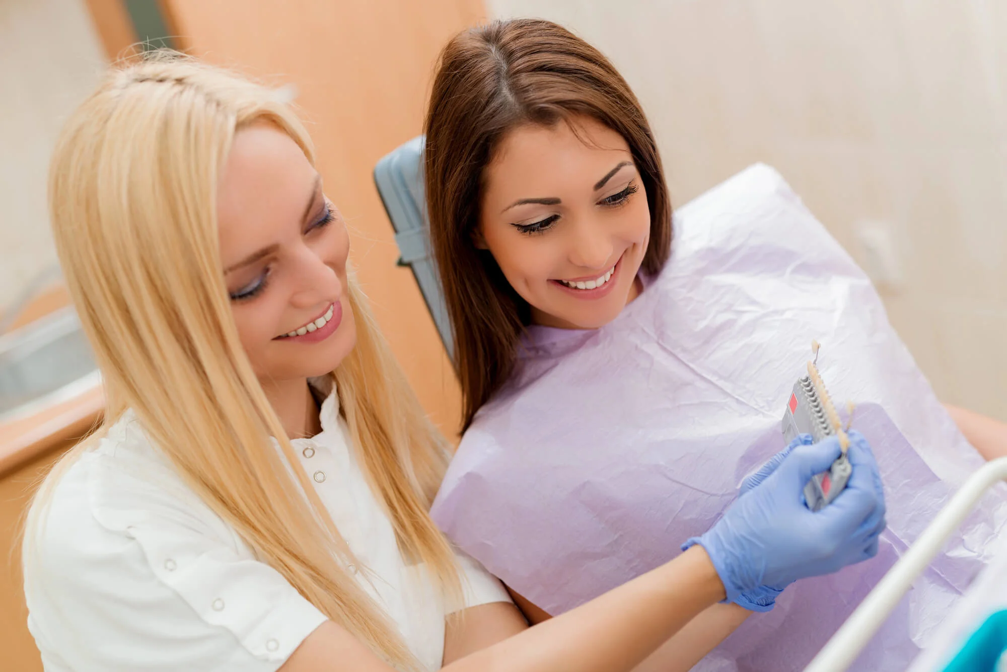 Dentist showing patient tooth shade guide dental crowns in Durham NC
