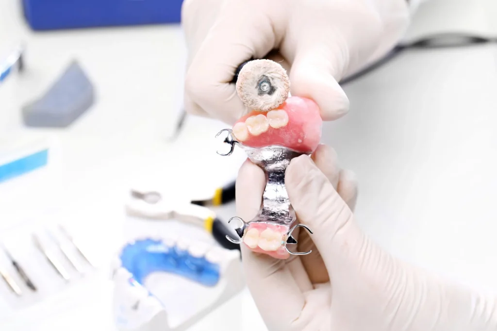 Dentist-holding-denture-to-replace-missing-teeth