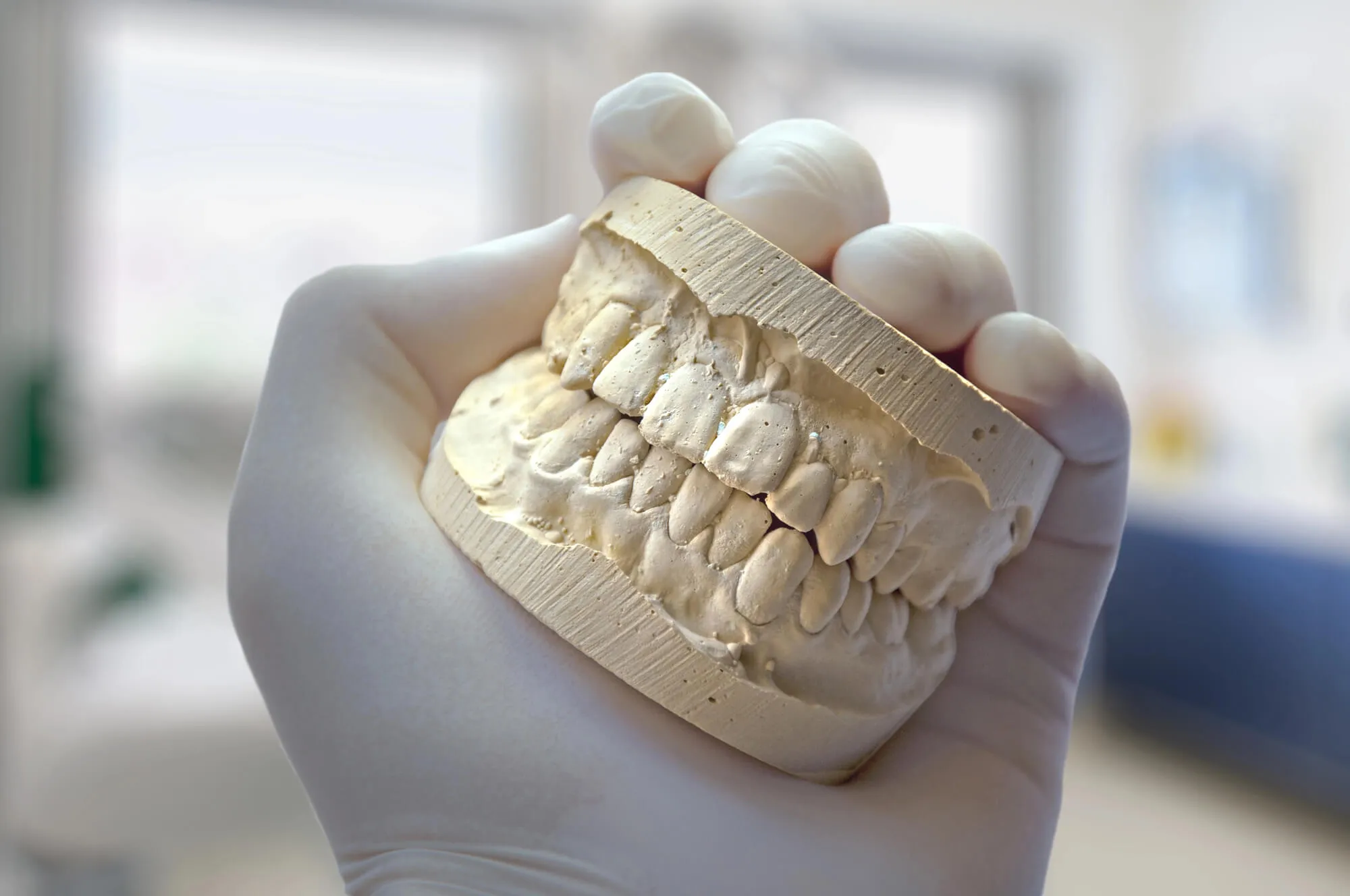 prosthodontic specialist durham holding a teeth model